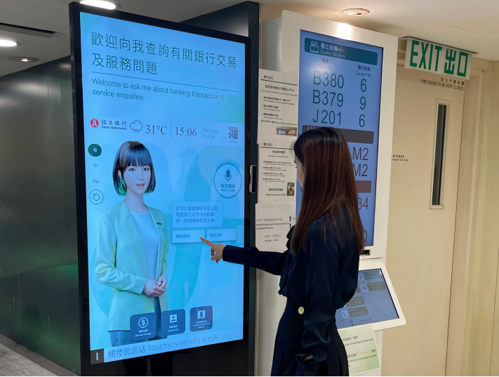 客戶試用智能接待系統。此系統可與客戶互動，直接回答客戶查詢，並且與恒生銀行原 有預約及櫃位取票系統無縫整合。